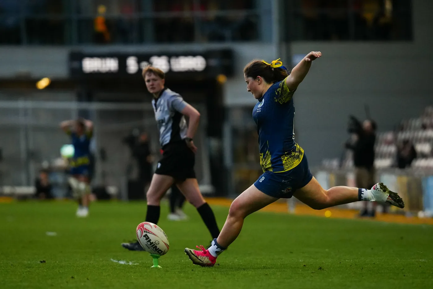 A player kicks the ball in front of a scoreboard during the 2026 Women's BUCS Super Rugby final