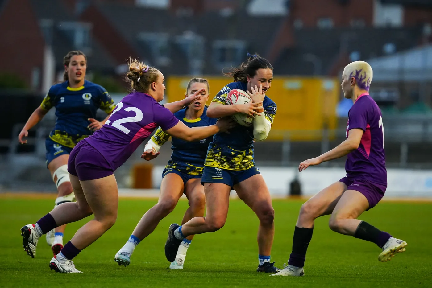 A player in navy and yellow carries the ball into a tackle during the 2026 Women's BUCS Super Rugby final