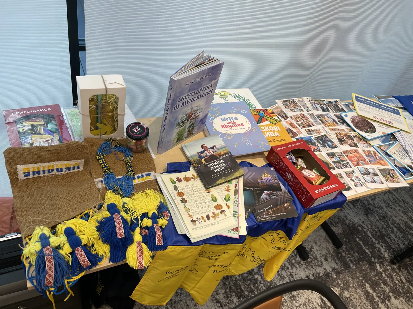 A display with Ukrainian flags, dolls in traditional dress and books laid over blue and yellow cloth