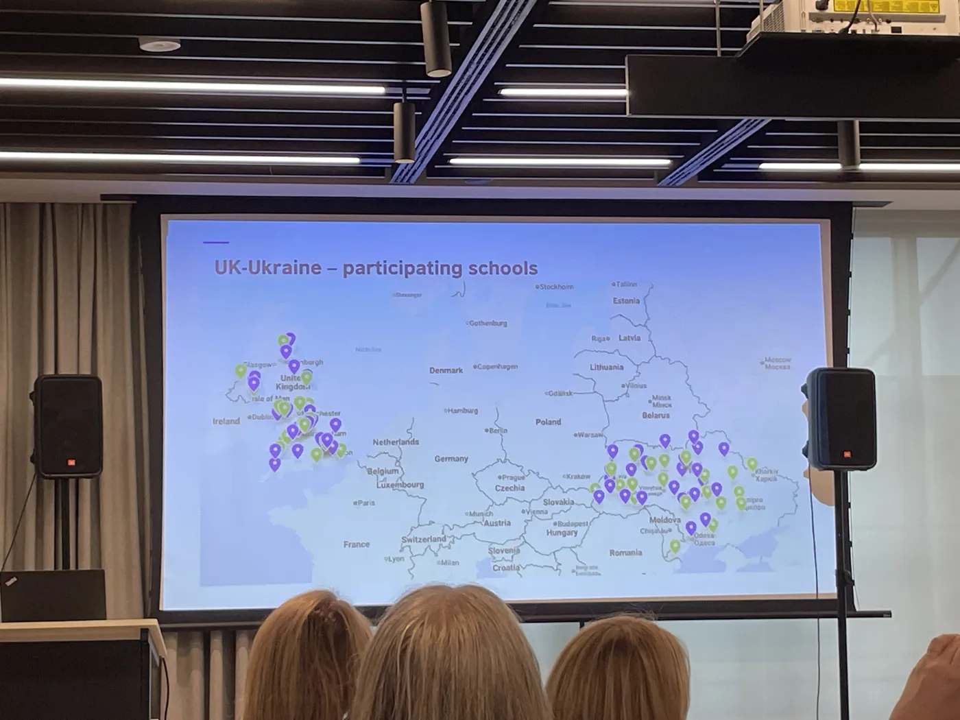 A projected slide titled UK-Ukraine participating schools showing a map with markers across the UK and Ukraine